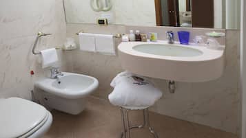 Un baño con inodoro, lavabo y espejo.