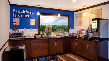 A modern kitchen with a large window, wooden cabinets, and a breakfast bar.