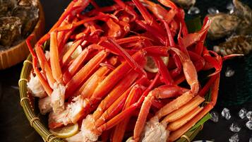 A basket filled with cooked crab legs and lemon slices.