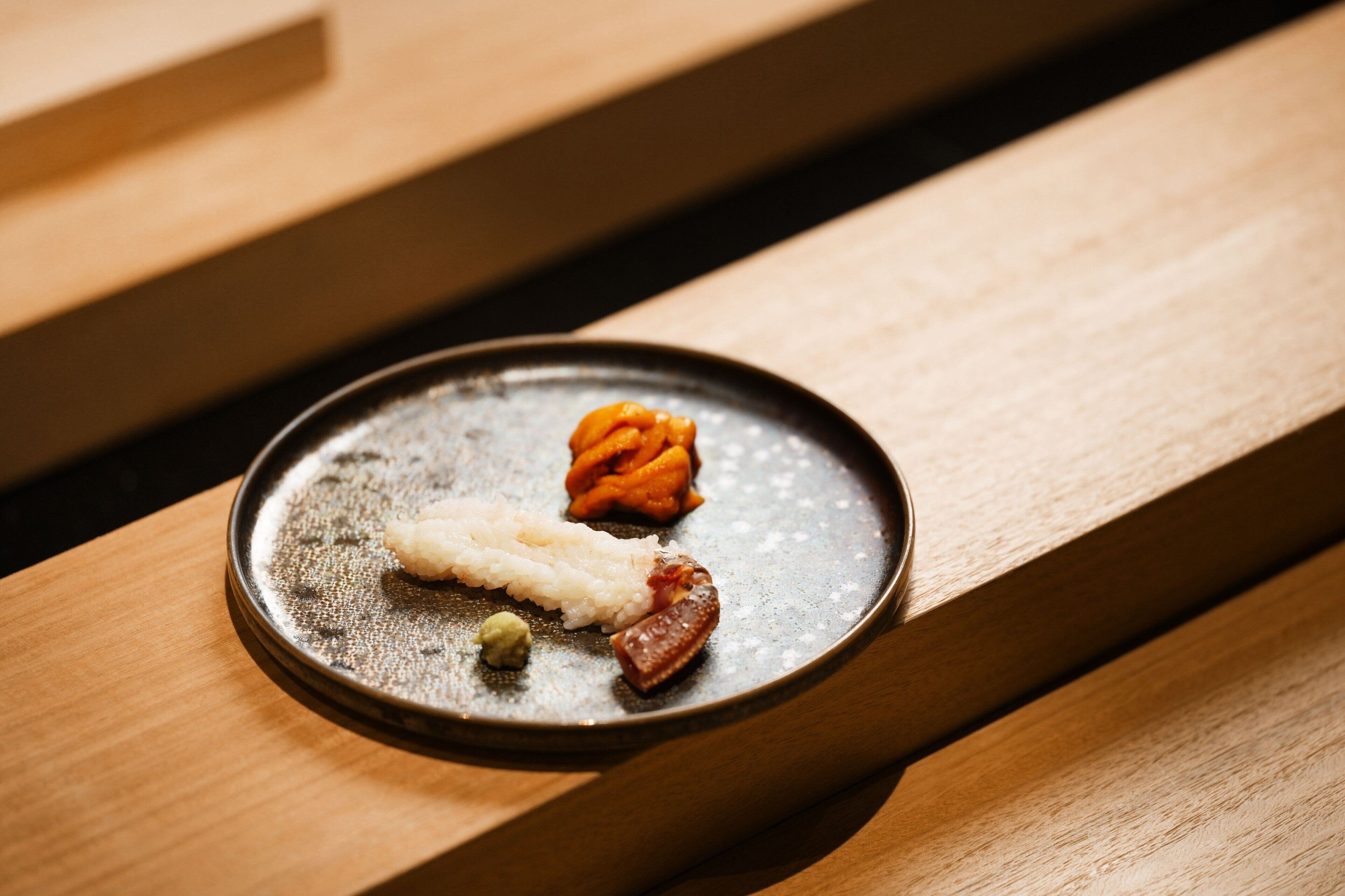 A plate with various food items on a wooden surface.
