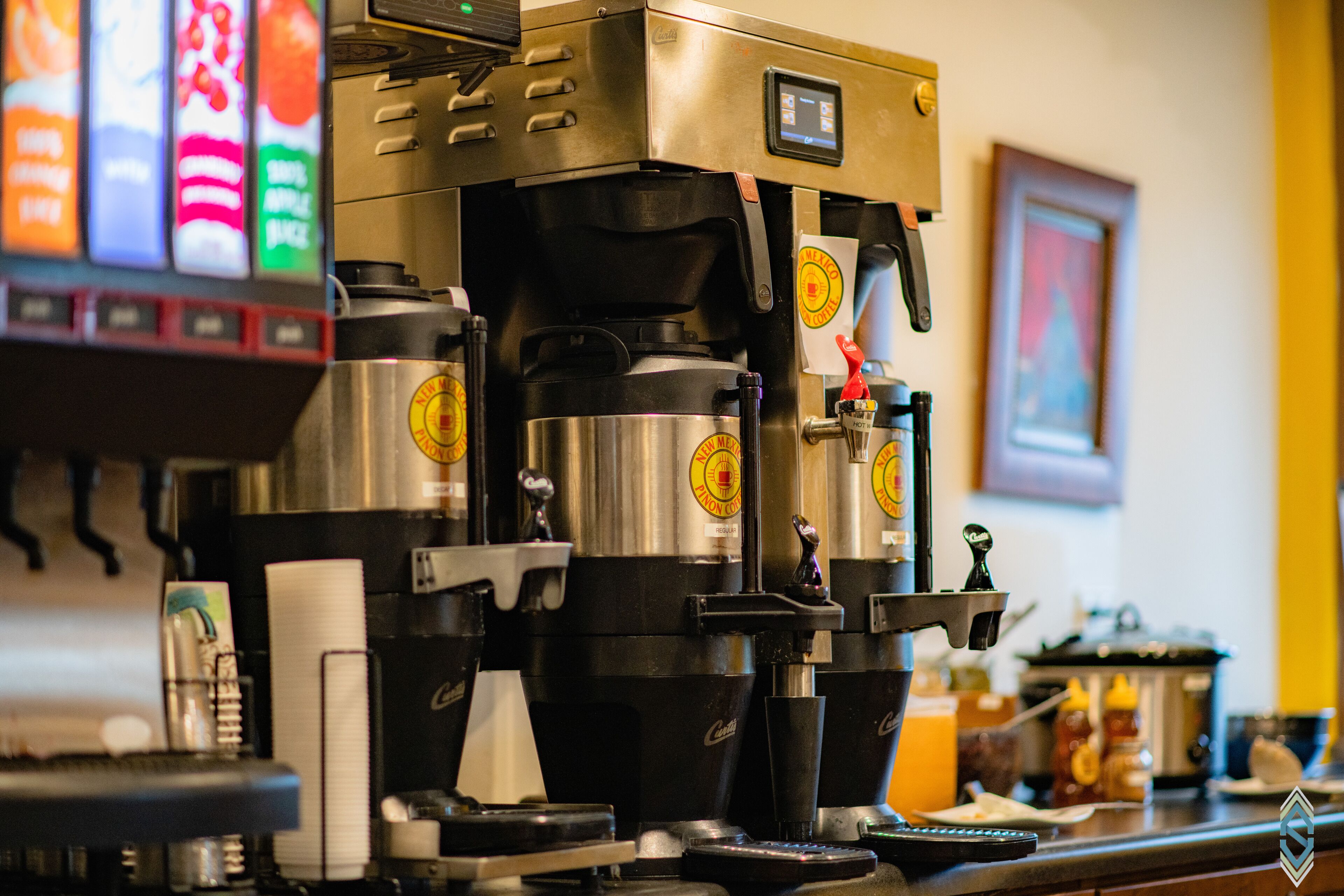 A coffee machine with a digital display and multiple coffee dispensers.