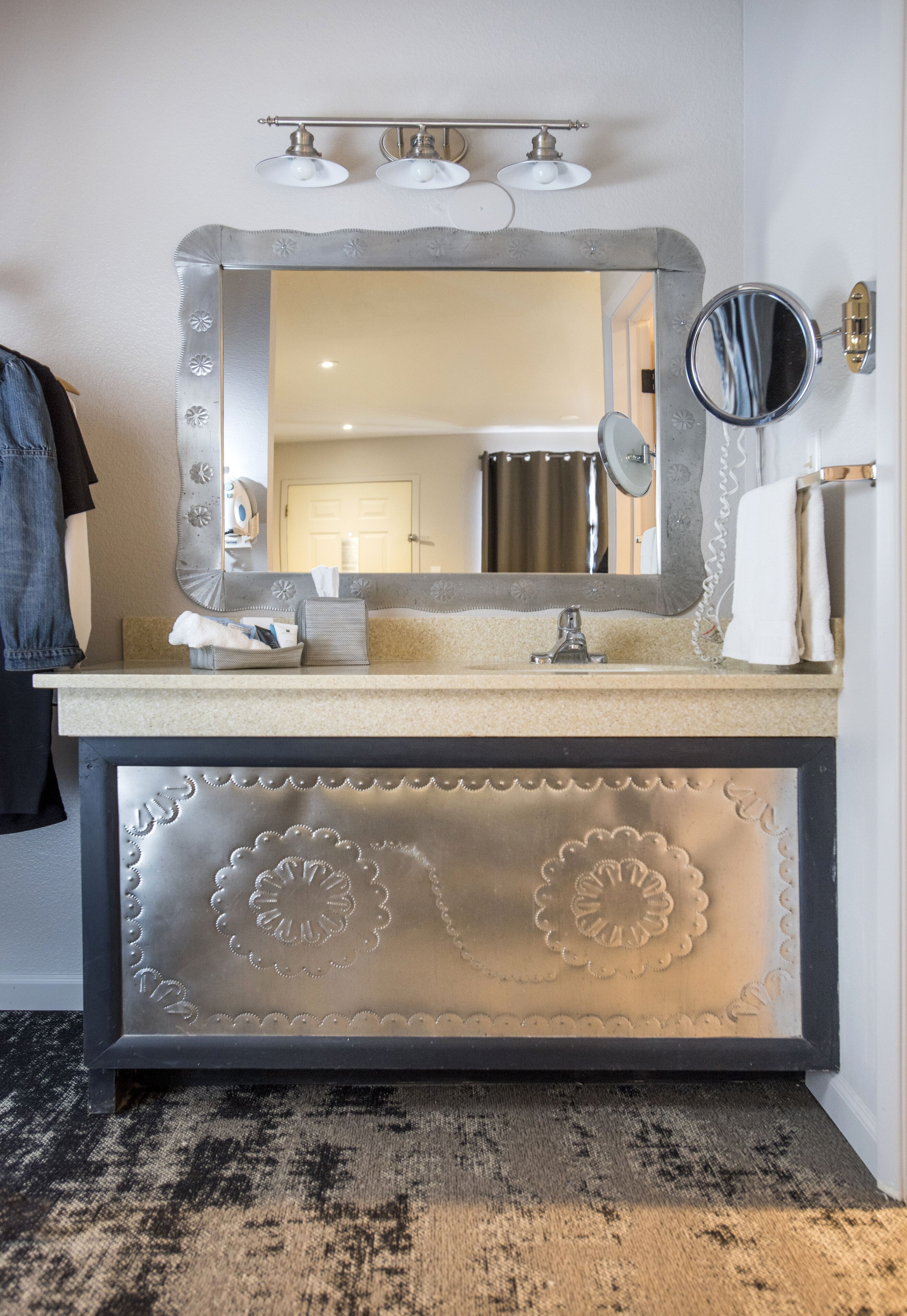 A bathroom vanity with a large mirror, a sink, and a towel rack.
