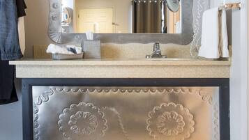 A bathroom vanity with a large mirror, a sink, and a towel rack.