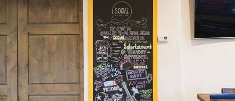 Un tableau noir affichant des informations sur les réseaux sociaux et les détails concernant un événement.