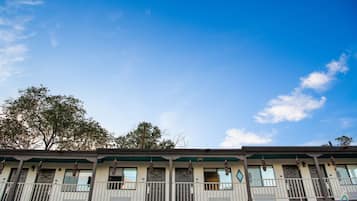 A row of motel-style buildings with balconies and hanging decorations.