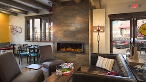 A cozy interior with a fireplace, seating area, and a view of the outside. - The Sage Hotel (Santa Fe)