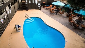 An outdoor swimming pool with lounge chairs and umbrellas.