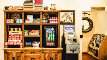 Una máquina expendedora, una cafetera y una selección de aperitivos en una habitación.