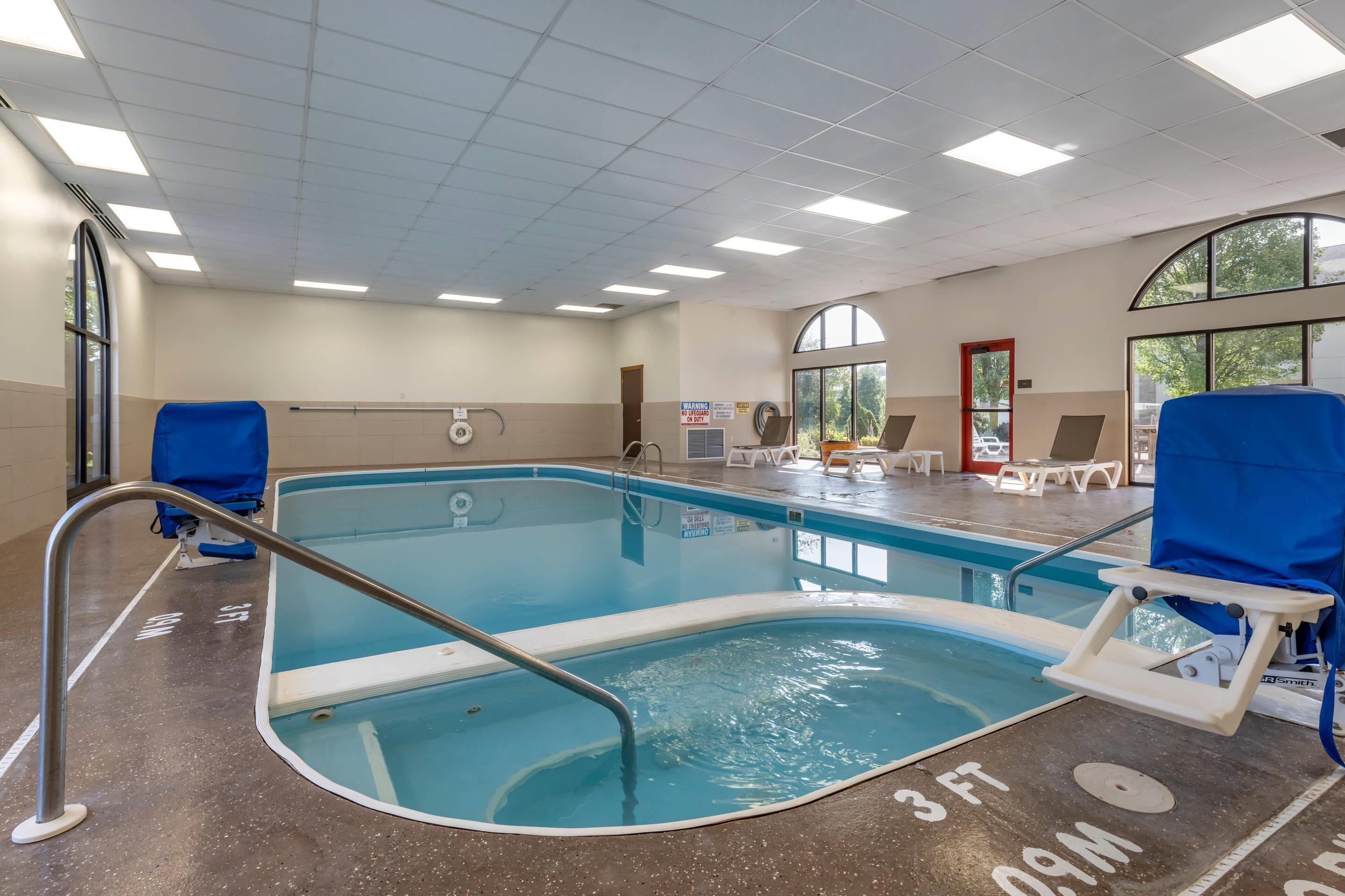 Piscina interior com indicador de profundidade de 90 centímetros, cadeira de salva-vidas e toldo.