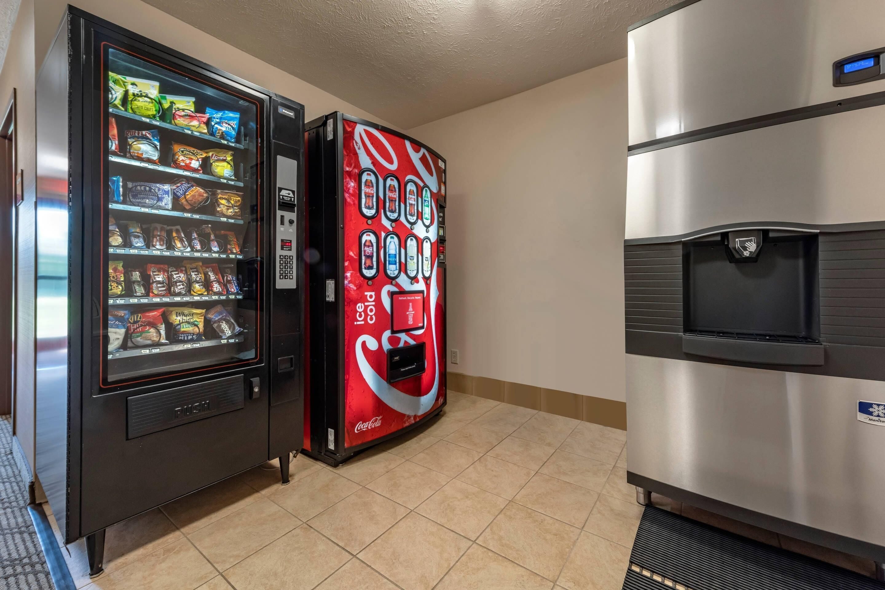 Een automaat met snacks en een Coca-Cola automaat, plus een waterdispenser.