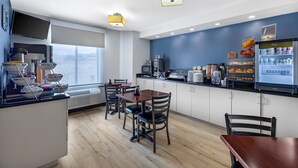 A modern kitchen with a dining area, equipped with a refrigerator, microwave, and various appliances. - Sleep Inn South Jordan - Sandy (South Jordan)