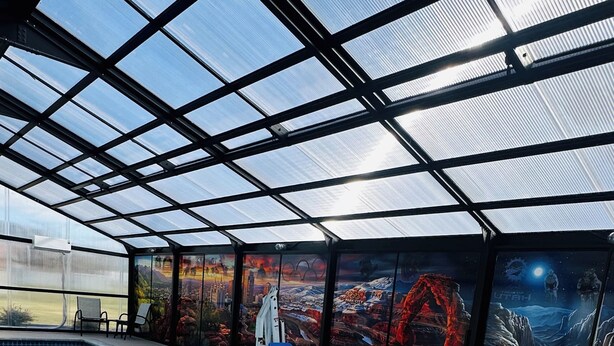 An indoor swimming pool with a glass ceiling, a hot tub, and a mural with a space theme. - Sleep Inn South Jordan - Sandy (South Jordan)