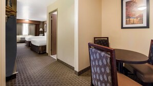 A hotel room with a bed, a desk, and a chair. There is a window with curtains and a painting on the wall. - Best Western Empire Towers (Sioux Falls)