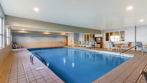 An indoor swimming pool with tiled floors, poolside chairs, and a clear view of the pool area. - Best Western Empire Towers (Sioux Falls)
