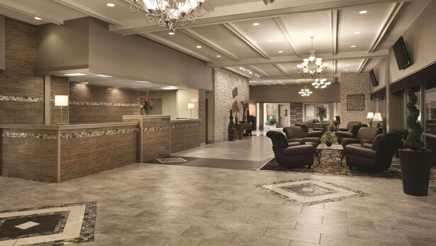 A spacious lobby with a reception desk, comfortable seating area, and a chandelier. - Radisson Hotel Louisville North (Clarksville)