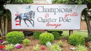 Une enseigne pour le bar « Champions & Quarter Pole », dont le thème est les courses de chevaux.