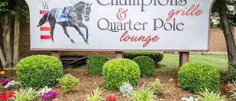 A sign for Champions & Quarter Pole lounge with a horse racing theme.