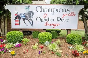 Señal para el bar Champions & Quarter Pole, con temática de carreras de caballos.