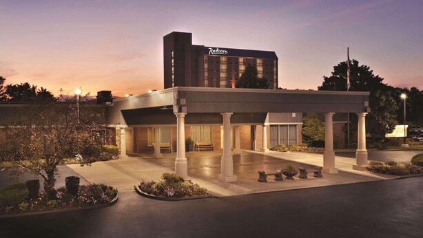 Un hôtel Radisson doté d’un espace extérieur abrité, de colonnes et d’une entrée bien éclairée.