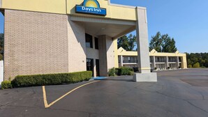 A Days Inn by Wyndham with a brick facade, a covered entrance, and a parking lot.