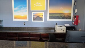 A kitchen with a granite countertop, a coffee machine, and a printer.