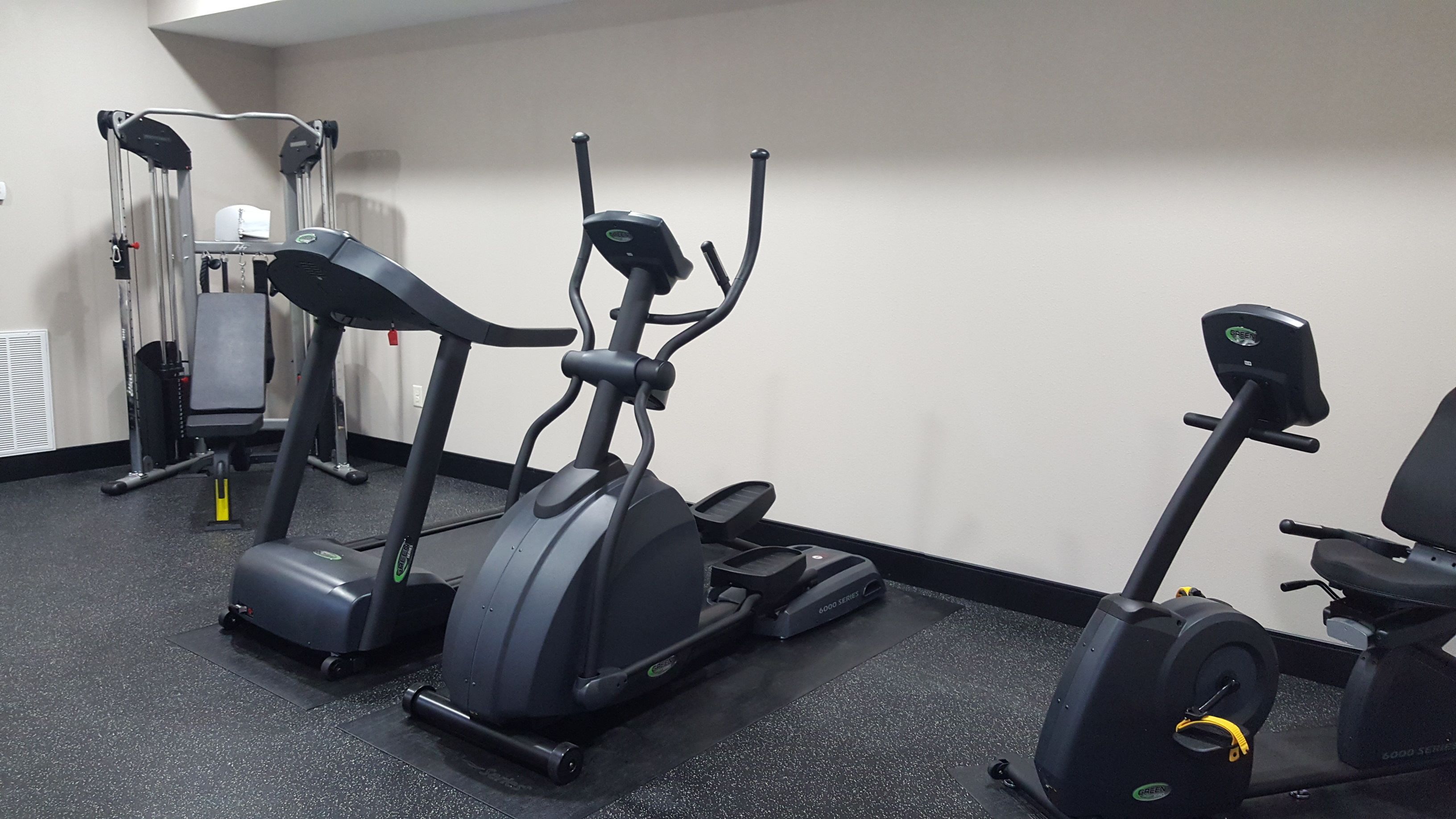 A gym with treadmills, elliptical machines, and a weight machine.