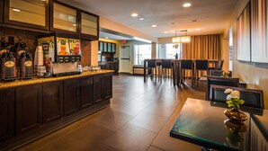 A hotel lobby with a bar area, seating, and a reception desk.