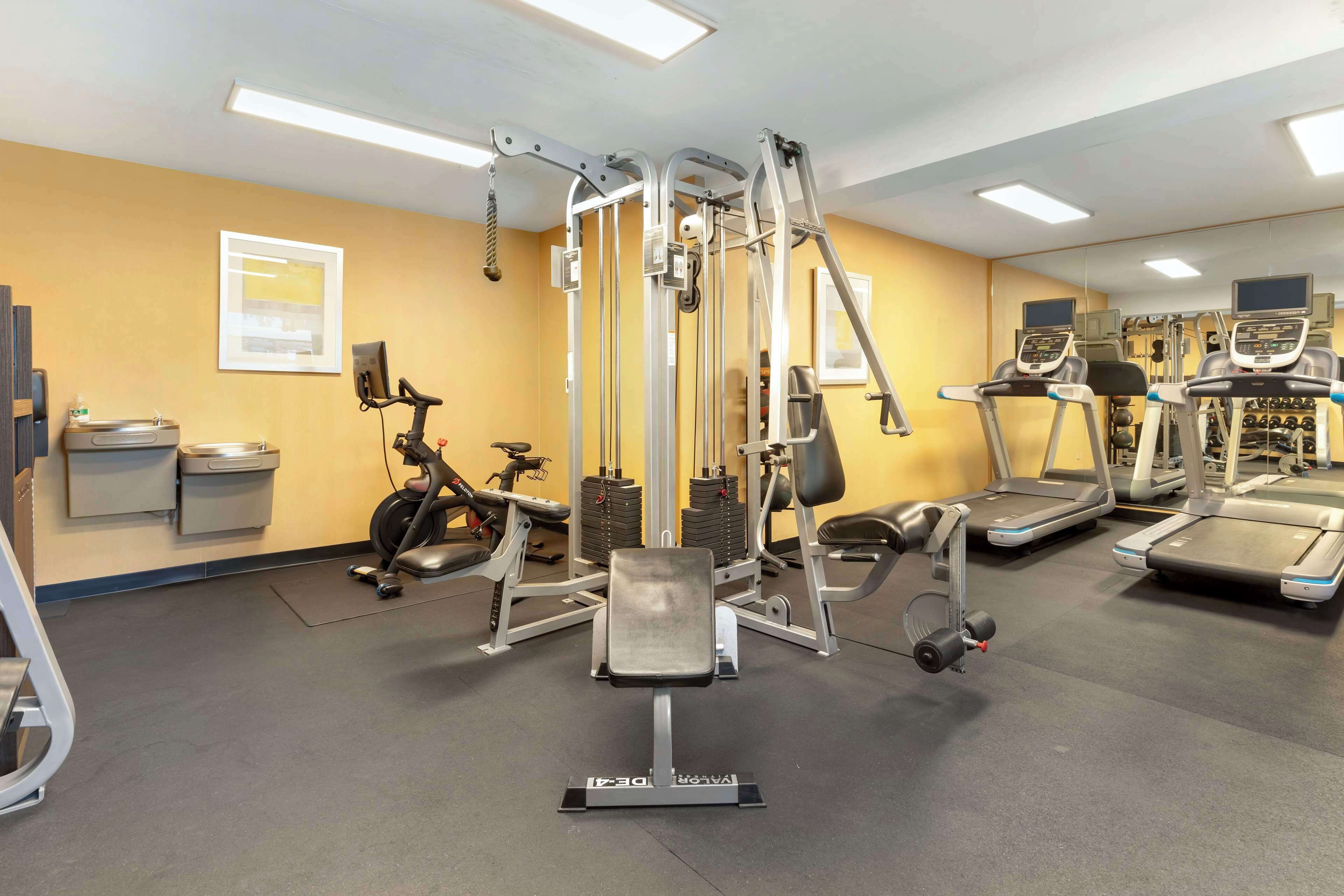 A gym with various exercise equipment, including treadmills and weight machines.