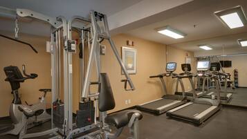 A gym with various exercise equipment, including treadmills, an elliptical, and weight machines.
