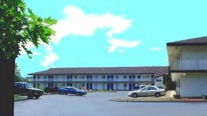 A two-story motel with a flat roof and a single-story annex. There are several cars parked in the driveway. - Hilltop Inn (Pittsburgh)
