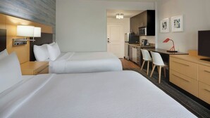 A hotel room with two beds, a desk, a chair, a TV, and a kitchenette. - TownePlace Suites by Marriott London (London)