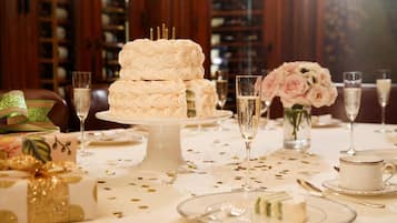 Ein festlich gedeckter Esstisch mit einer mehrstöckigen weißen Torte, Champagnergläsern und floralen Dekorationen.