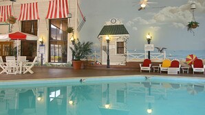 A pool area with lounge chairs, a small building with a sign, and a mural of a beach scene. - Millennium Hotel Durham (Durham)