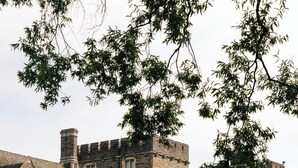 A large stone building with multiple towers and windows, surrounded by a grassy area with trees. - Millennium Hotel Durham (Durham)