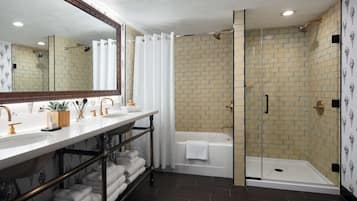 Un baño con tocador doble, bañera y ducha con cerramiento de vidrio.