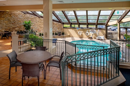 Una piscina techada, una piscina al aire libre de temporada, sombrillas