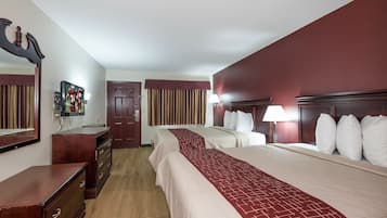 Habitación de hotel con dos camas, un aparador, un espejo, un televisor y una puerta.