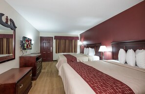 A hotel room with two beds, a dresser, a mirror, a television, and a door. - Red Roof Inn Chipley (Chipley)