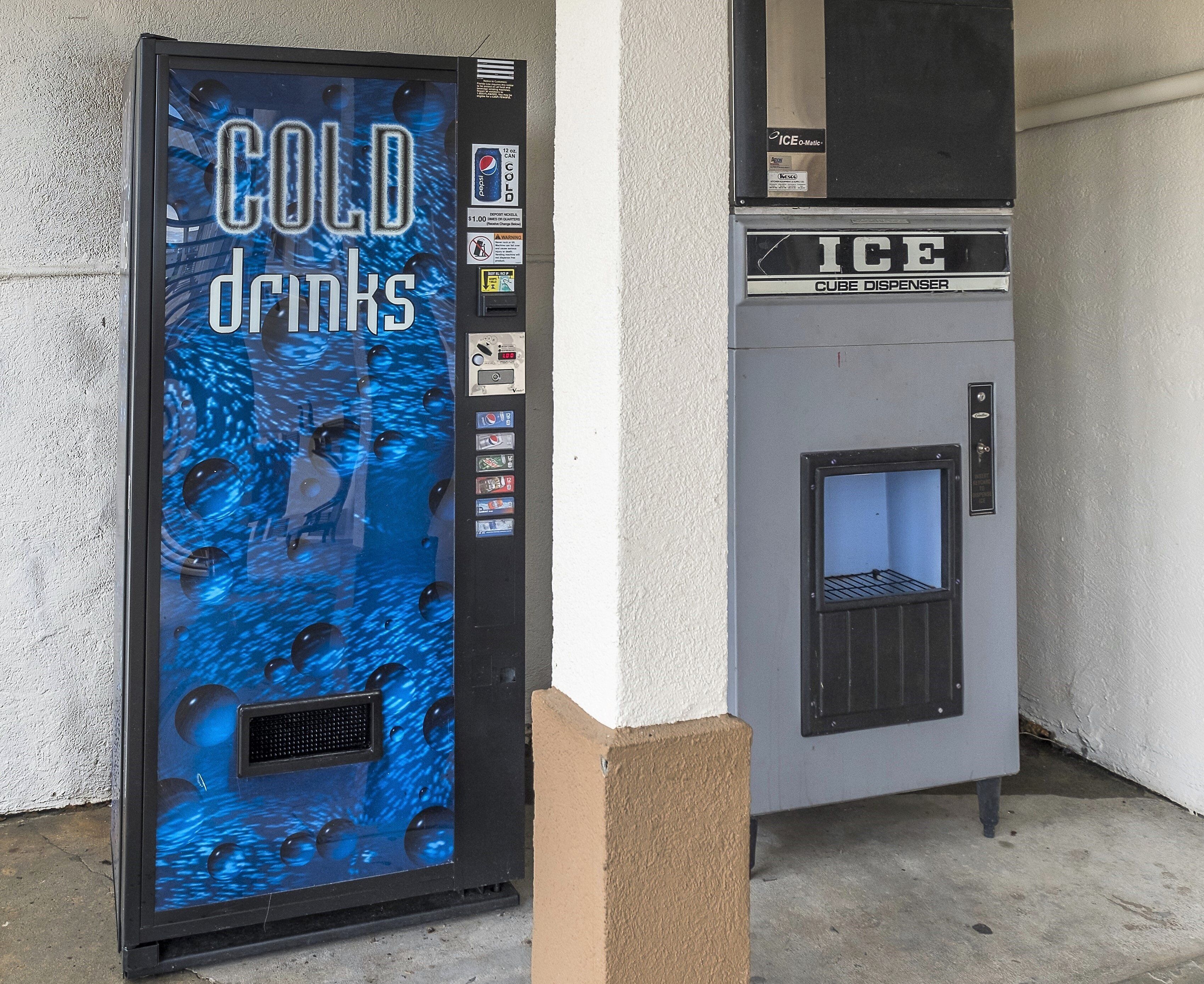 A vending machine with a blue design labeled 'COLD drinks' and a smaller dispenser labeled 'ICE' on top.
