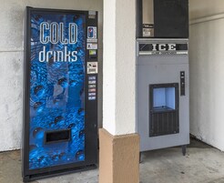 Una macchina distributrice automatica con un design blu, con l'indicazione 'COLD drinks', e un distributore più piccolo con la scritta 'ICE' sopra.