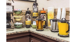 A buffet setup with various drink dispensers, including hot water, regular water, and coffee options.