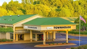 A two-story building with a green roof and a sign reading "OYO TOWNHOUSE".