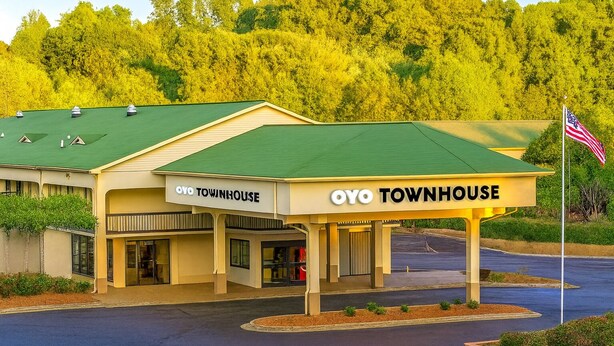 Un immeuble de deux étages doté d’un toit végétalisé et d’une enseigne indiquant « OYO TOWNHOUSE ».