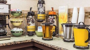 A buffet setup with various drink dispensers, including hot water, regular water, and coffee options. - Townhouse Winston Salem - University (Winston-Salem)