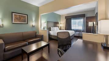Ein Hotelzimmer mit Bett, einer Couch, einem Schreibtisch und einem Sessel.