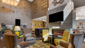 A modern lobby with seating areas, a flat-screen TV, and a fireplace. - Best Western Hilliard Inn & Suites (Hilliard)
