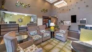 A hotel lobby with seating, a reception desk, a refrigerator, and a television. - Best Western Hilliard Inn & Suites (Hilliard)