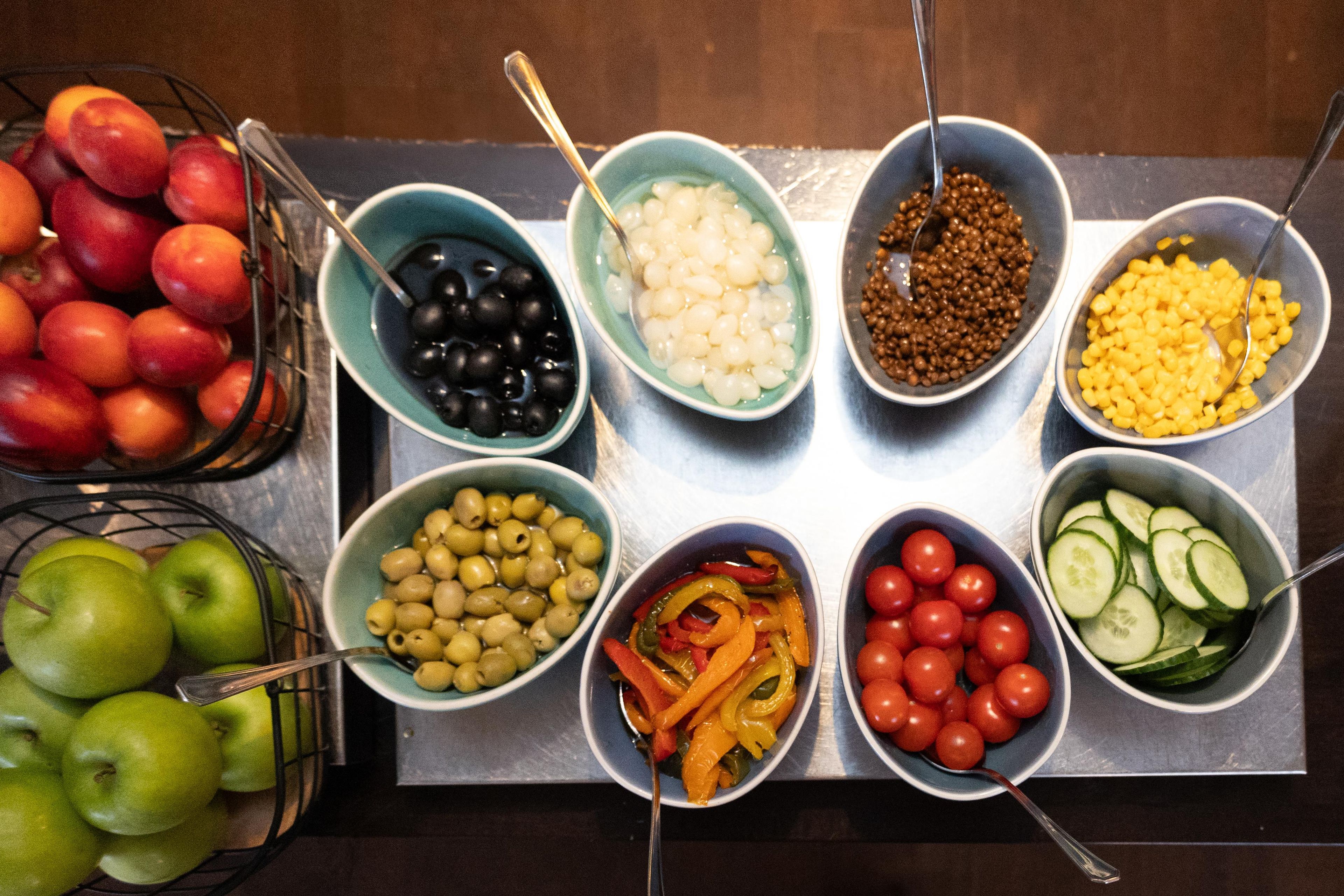 A table with various food items in bowls, including fruits, vegetables, and legumes.