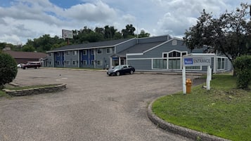 A motel with a sign indicating the entrance.