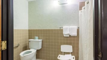 A bathroom with a toilet, a shower curtain, and a towel rack.